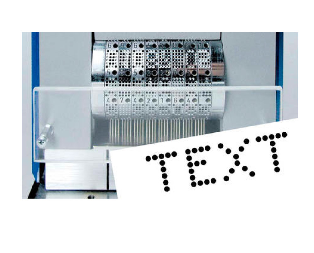 Perforationsmaschine Detail mit perforiertem Text Detailansicht einer Perforationsmaschine mit eingesetzten Nadeln und einer perforierten Papierprobe mit dem Schriftzug „TEXT“