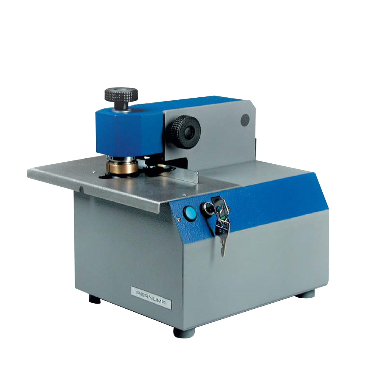 PERNUMA EMBOSSET Prägemaschine Frontansicht Elektrische Prägemaschine PERNUMA EMBOSSET in schräger Frontansicht. Sichtbar sind das Metallgehäuse mit blauer Abdeckung, der Prägestempelbereich auf der Arbeitsplatte, ein seitlicher Drehknopf, eine grüne Kontrollleuchte sowie ein Sicherheitsschloss mit