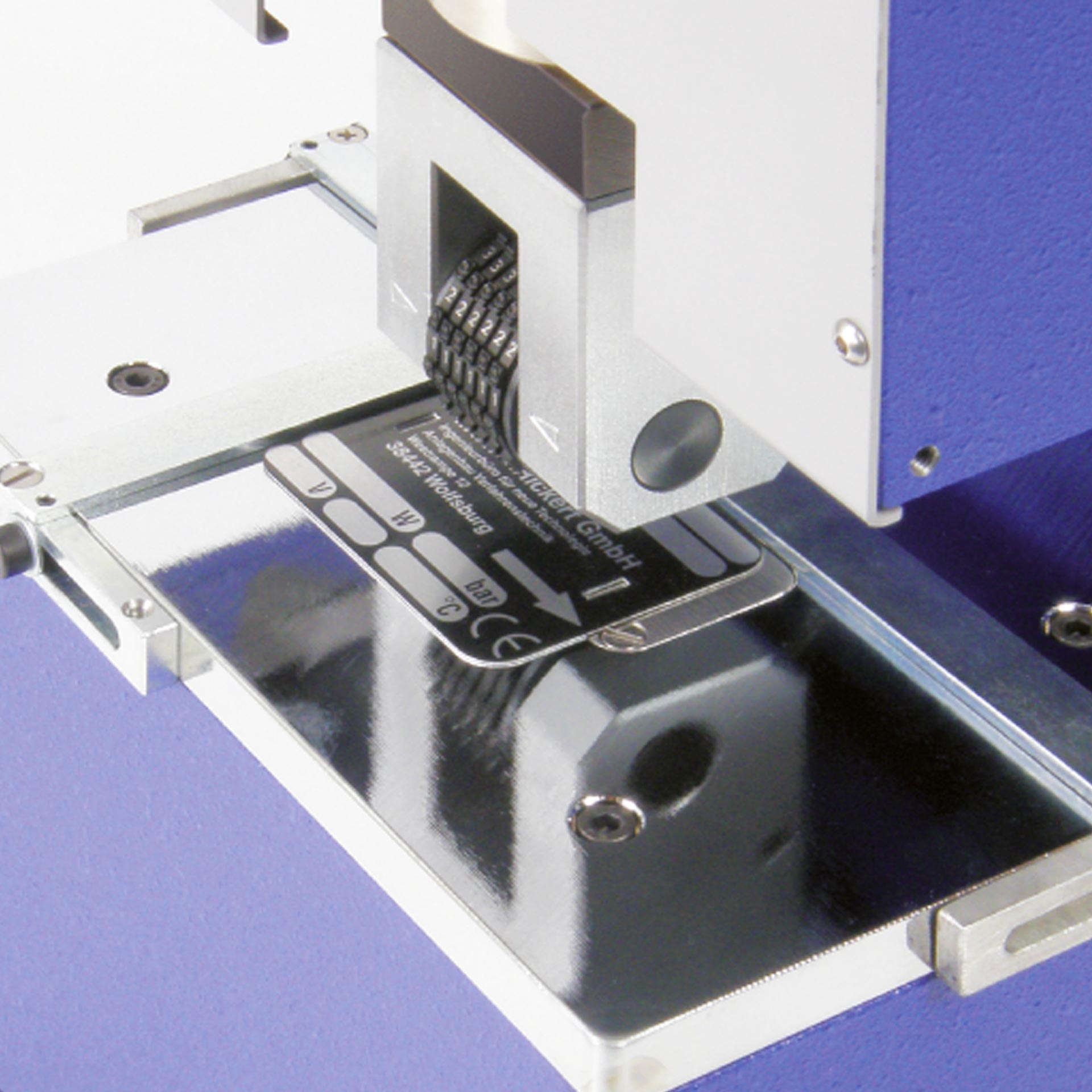 Beispielbild: PERNUMA METALLPRINT E Detail Prägen Metallschild Detailansicht der Prägeeinheit der PERNUMA METALLPRINT E beim Prägen eines Metallschildes, Beispielanwendung
