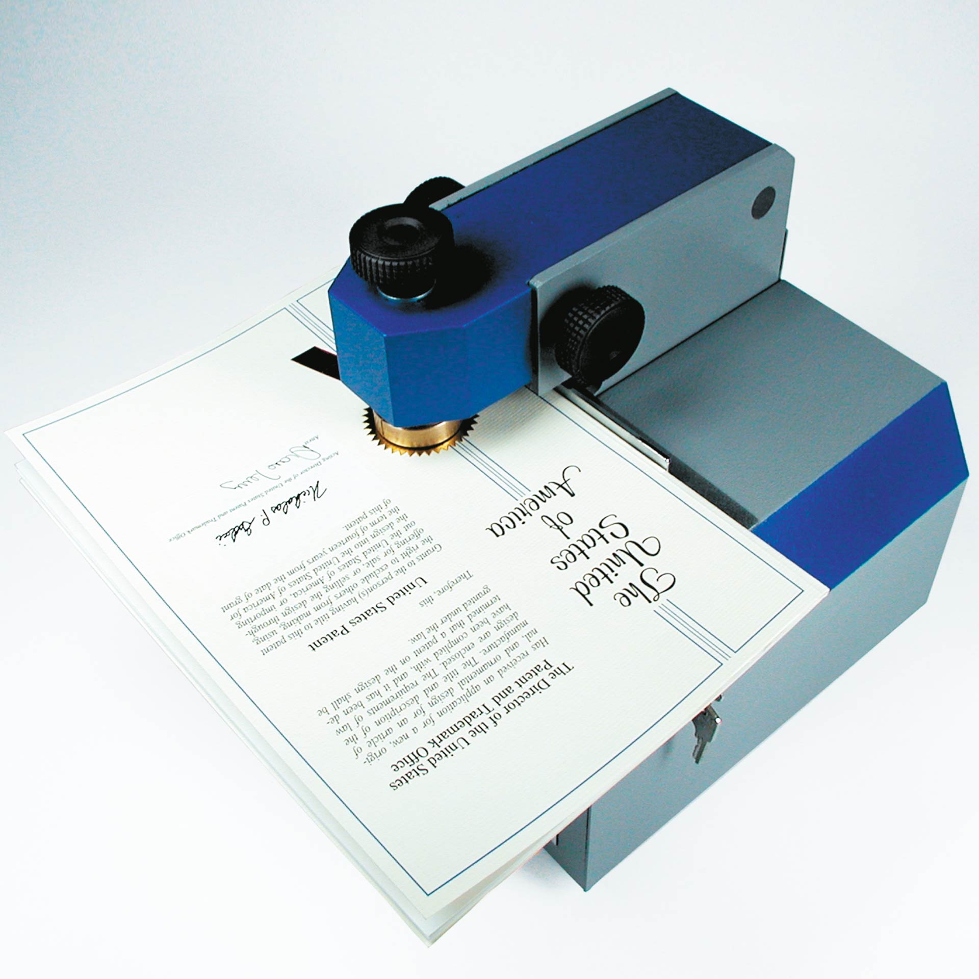 PERNUMA EMBOSSET Prägemaschine Anwendung mit Papier PERNUMA EMBOSSET Prägemaschine bei der Anwendung. Ein Papierstapel wird unter dem Prägestempel positioniert, während der Stempelbereich der Maschine eine Prägung in das Dokument setzt.