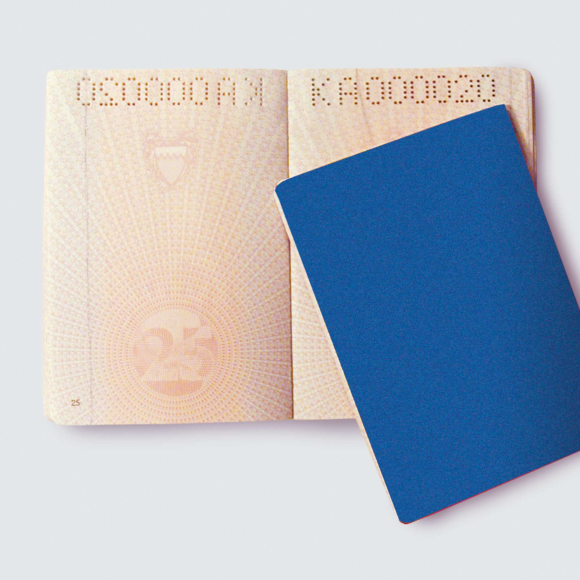 Papier Perforation Pernuma Beispiel einer PERNUMA PERFOSTAR Perforierung in einem aufgeklappten Dokument mit gelochter Buchstabenfolge im oberen Bereich, teilweise von einer blauen Ausweis verdeckt.