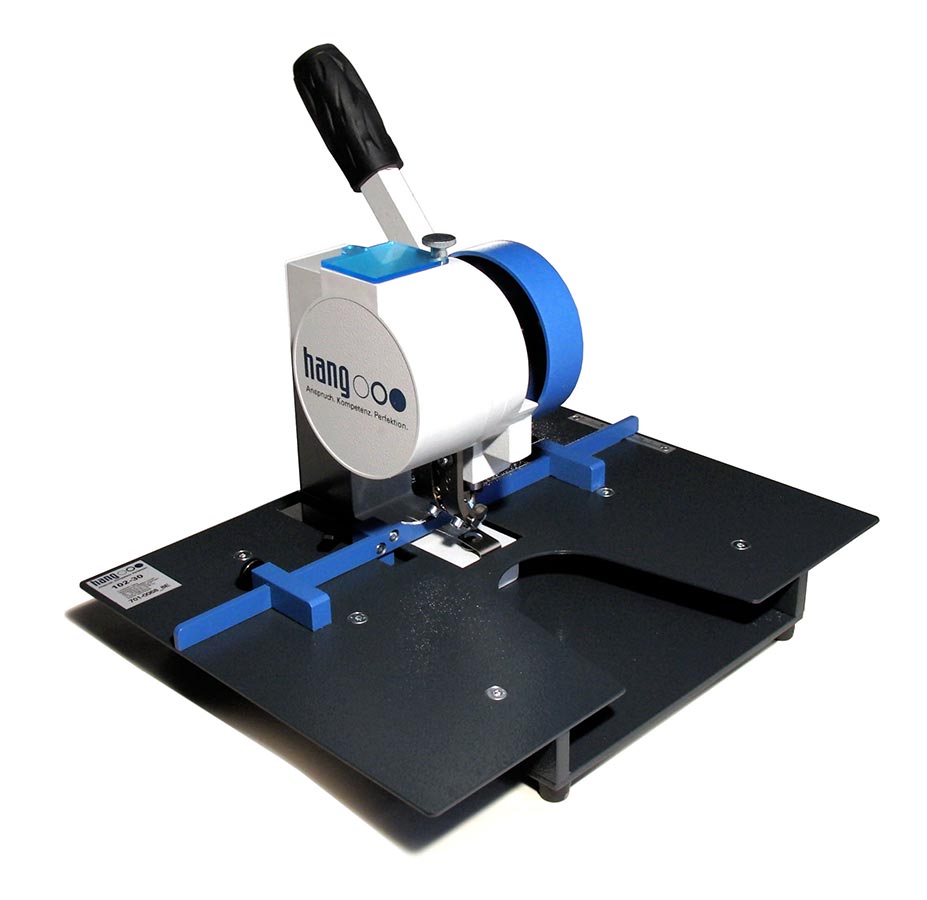 HANG 102-30 Komfort – Gesamtansicht HANG 102-30 Komfort Ösenpresse in schräger Vorderansicht mit Handhebel, schwarzer Materialauflage und blauen Anschlägen.