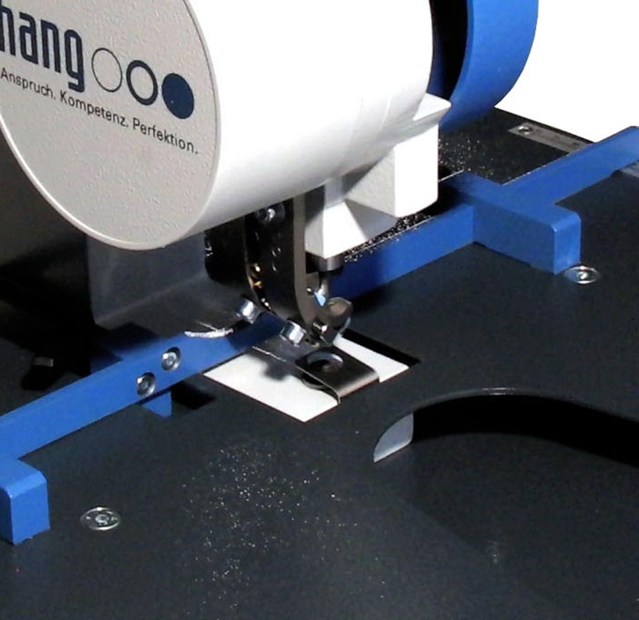 HANG 102-30 Komfort – Arbeitsbereich Detailansicht des Arbeitsbereichs der HANG 102-30 Komfort mit Öswerkzeug, Materialauflage und blauen Anschlägen.