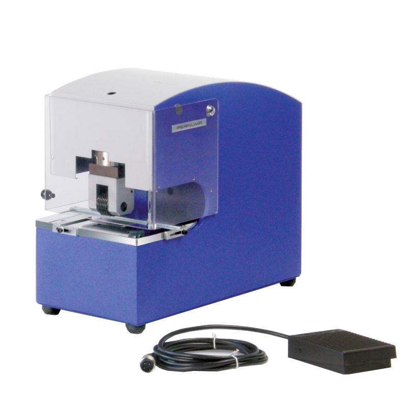 PERNUMA METALLPRINT E Prägemaschine mit Fußschalter Elektrische Prägemaschine PERNUMA METALLPRINT E in schräger Vorderansicht mit transparentem Schutzgehäuse, Prägeeinheit und angeschlossenem Fußschalter