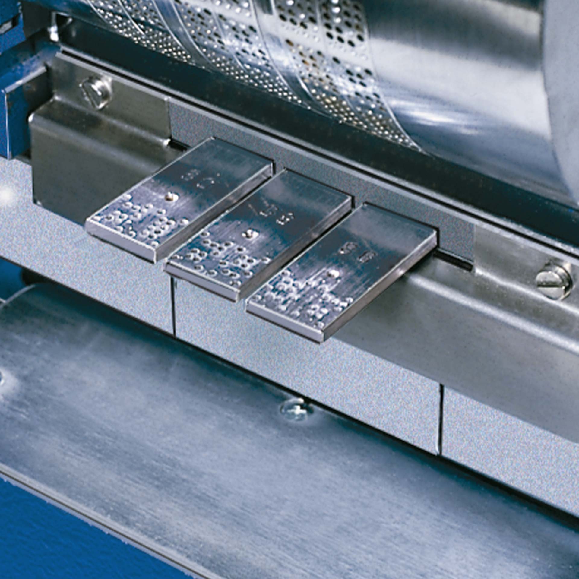 PERNUMA PERFOSTAR Detailansicht Detailansicht der PERNUMA PERFOSTAR mit eingesetzten Metallschiebern vor dem Räderwerk und sichtbarer Perforationsmechanik.